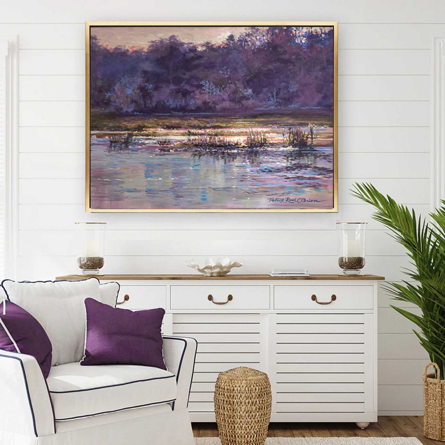 Living room with a painting of a marsh scene by Patrick Reid O'Brien with white chair, purple pillows, and a white console table.