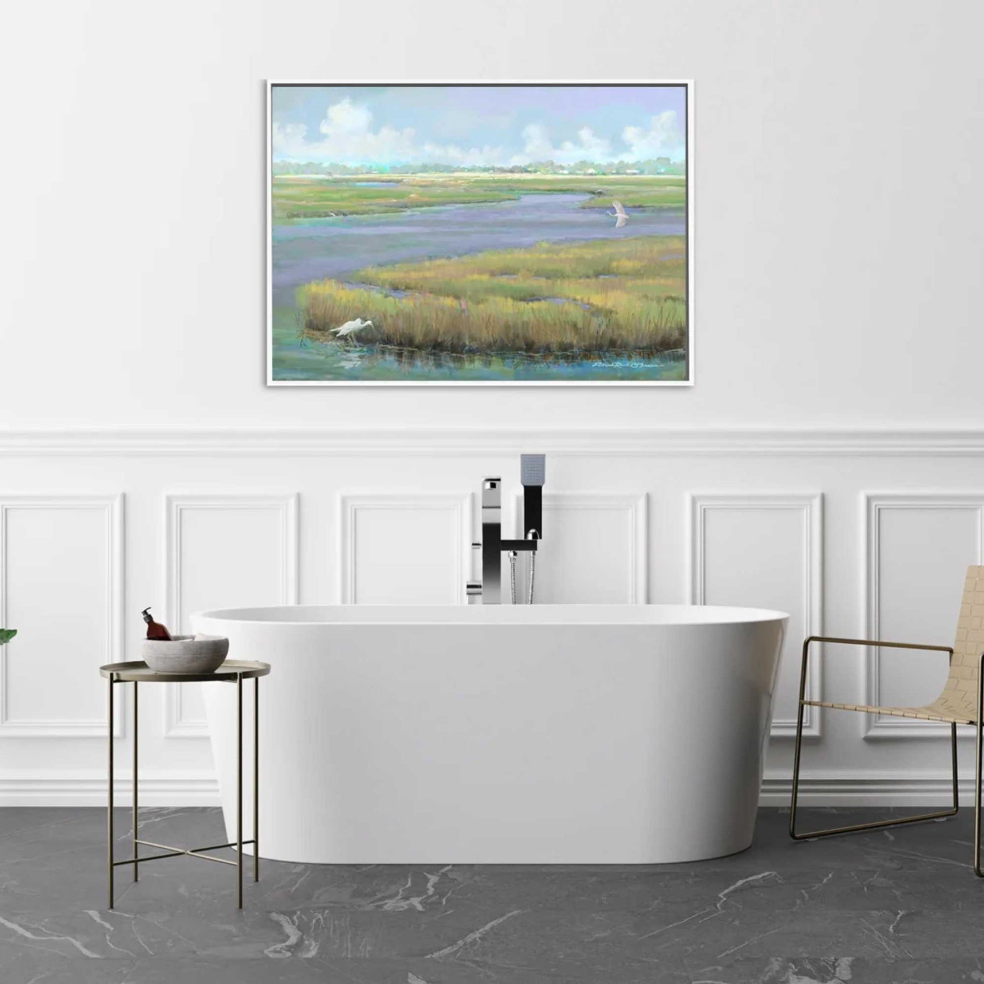 Modern bathroom with a freestanding bathtub, sink, and framed artwork of a natural marsh scene by Patrick Reid O'Brien.