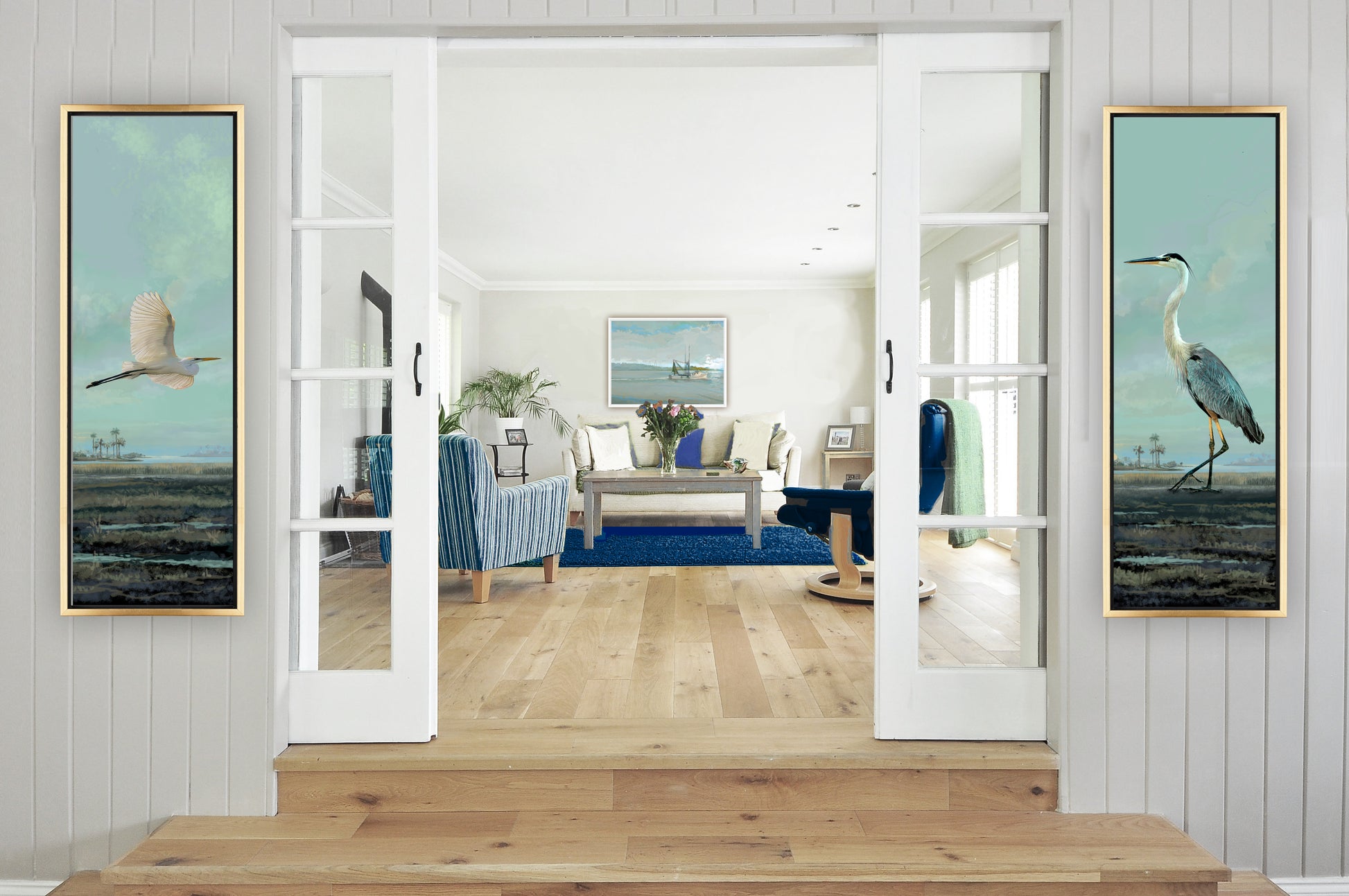 Living room with large mirror, framed artwork of birds, and wooden floor.