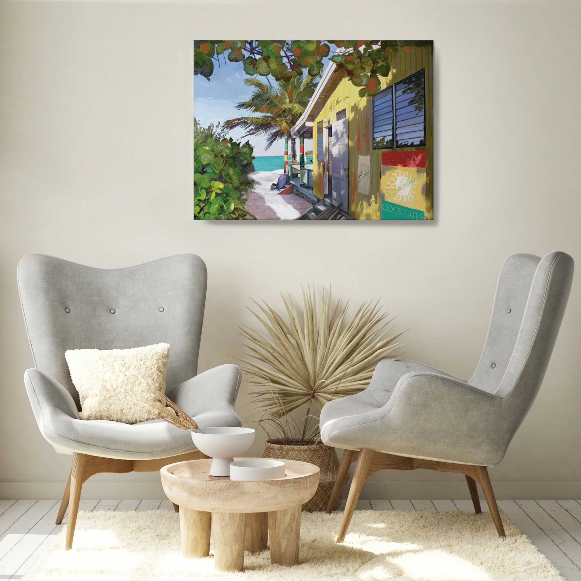 Living room with two gray armchairs, a small table, and a colorful beach scene painting on the wall.