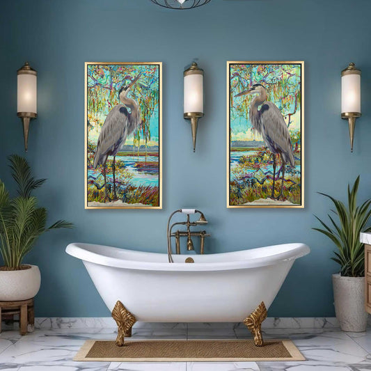 Bathroom with a white freestanding bathtub, gold feet, and two framed artworks of herons on a blue wall.