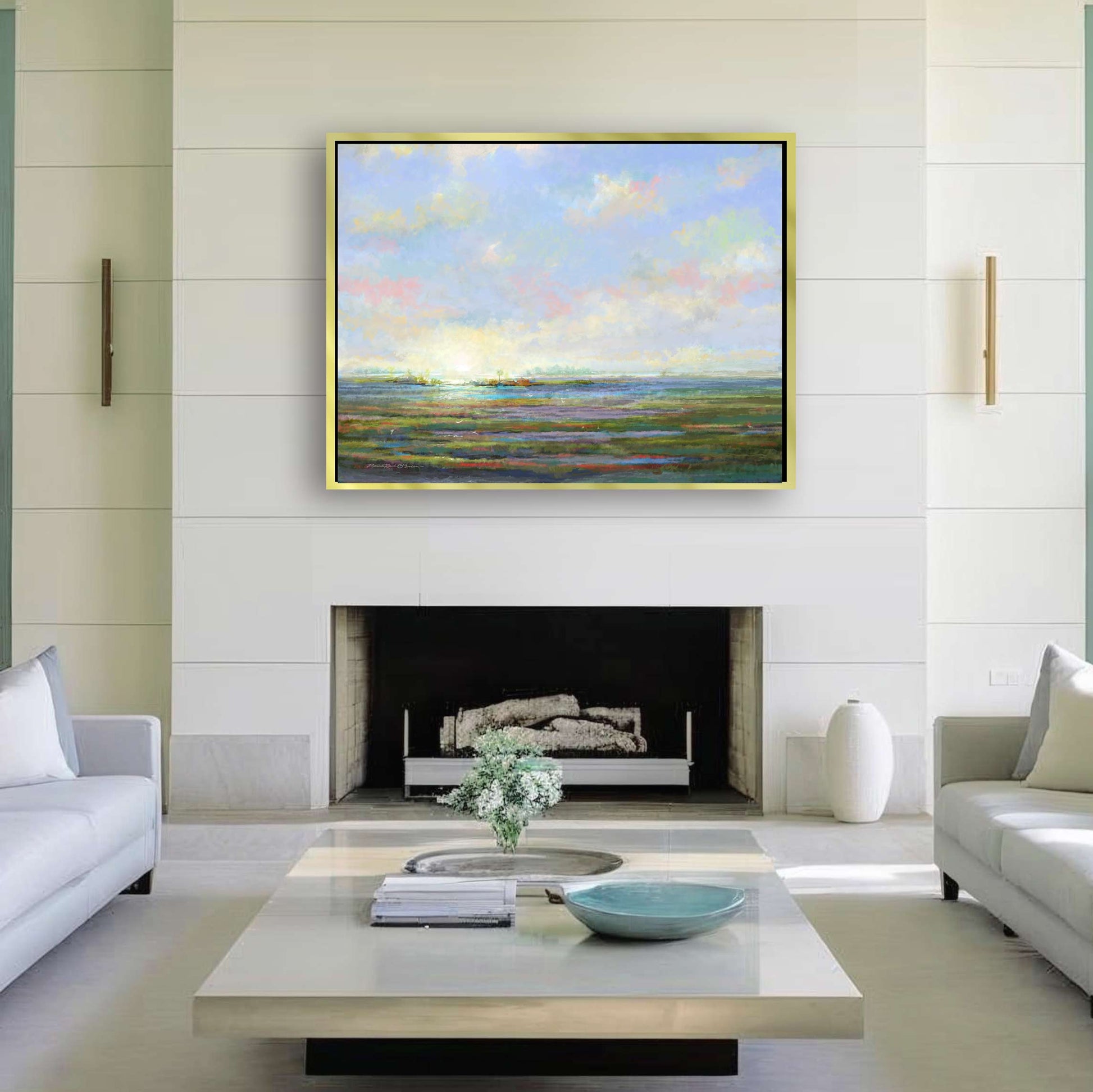 Modern living room with a painting of a landscape above a fireplace.