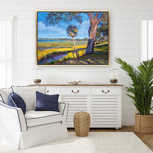 Living room with a coastal landscape by Patrick Reid O'Brien on the wall, white sofa, and decorative items.